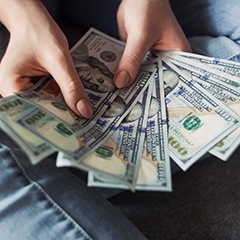 Woman’s hands holding cash fanned out
