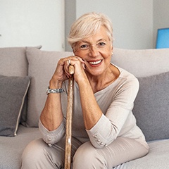 An older smiling woman sitting on a couch