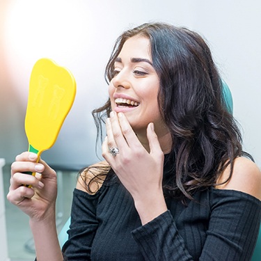 Woman at dentist looking in mirror