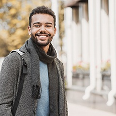 a smiling student standing outside of a building