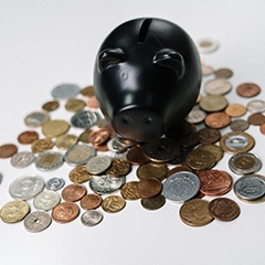 Black piggy bank on loose coins