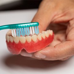 Man brushing dentures