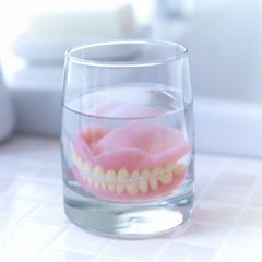 Dentures soaking in a glass