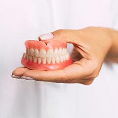Dentist holding full dentures in Sunnyvale