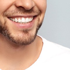 Close-up of a bearded man in a white shirt smiling