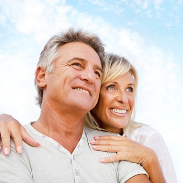 Older couple with implant dentures In Sunnyvale smiling outside