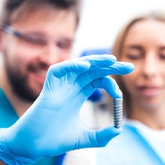 Implant dentist in Sunnyvale holding model of a dental implant