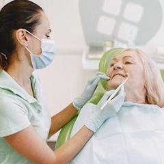 Older woman being examined by implant dentist in Sunnyvale