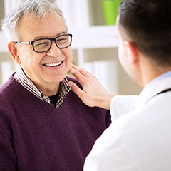 dentist putting his hand on a patient’s shoulder