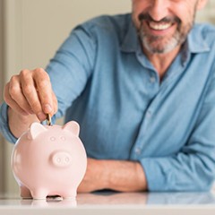 man putting coins into a piggy bank