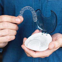 a person holding Invisalign aligners