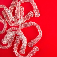 Invisalign clear aligners on red background