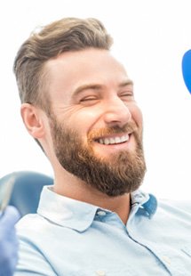 patient smiling while looking in dental mirror 