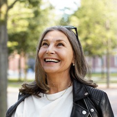 Senior woman with sunglasses on head smiling and walking outside