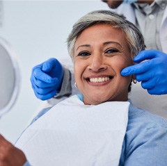 a woman smiling and holding a mirror