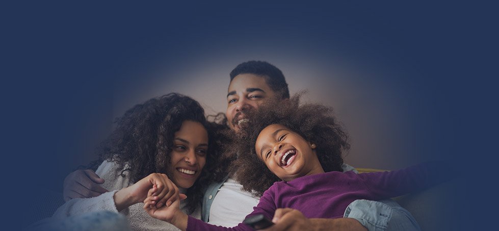 Family of three laughing on couch