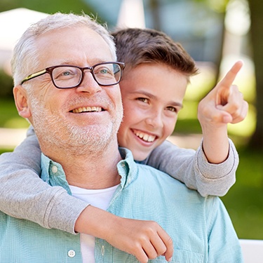 Smiling man and child outdoors