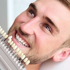 Man's smile compared with tooth color chart