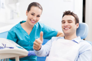 Man in dental chair next to dental hygienist