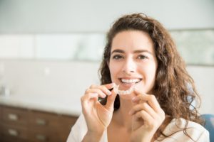 Woman holding aligner for Invisalign in Sunnyvale. 