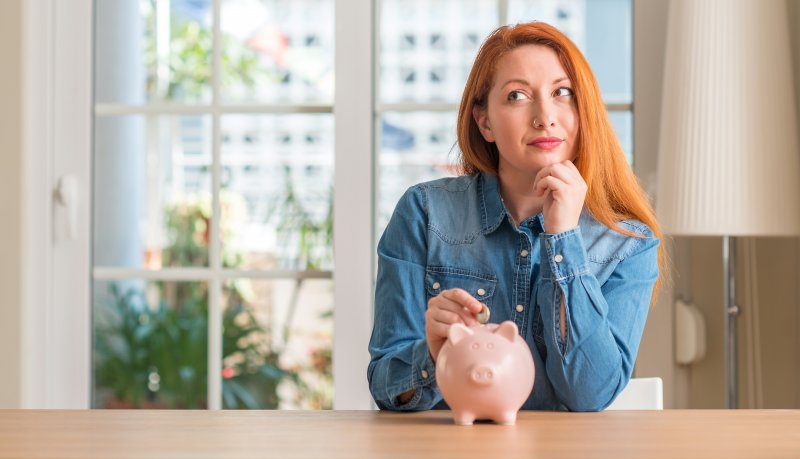 Woman putting coin in piggy bank