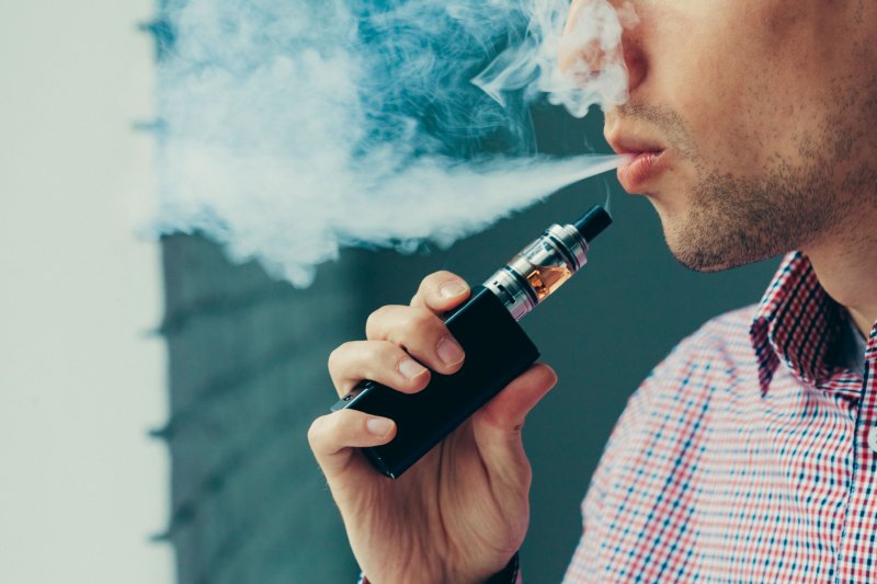 Man blowing out smoke from his vape