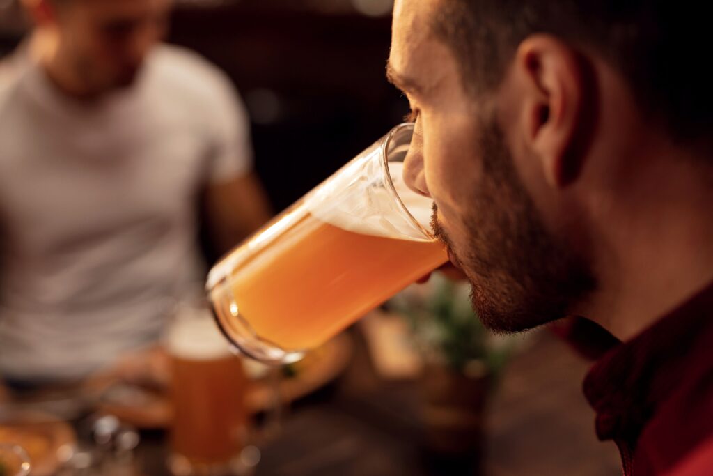 Man sipping a light amber beer